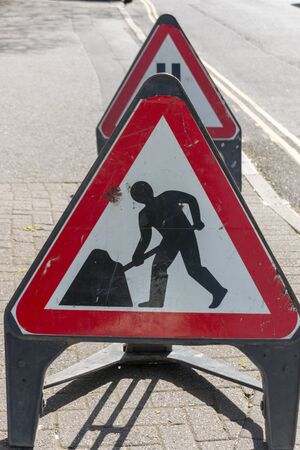 Bristol-April 2020-England-a close up view of warning road working signs on a side road の写真素材