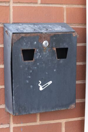 a close up view of a metal cigarette box used to put out and collect cigarette buds の写真素材
