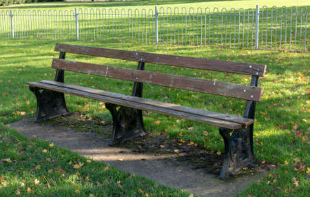 a close up view of wooden and metal bench in a open public parkの写真素材