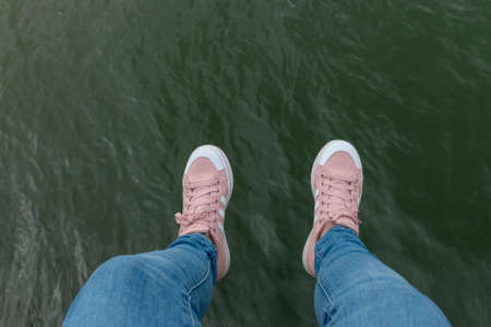 A close up view of a pair of legs hanging off a side of the harbourの写真素材