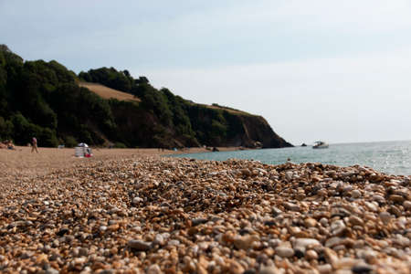 A close up view of the different pebbles on the beach at blackpool sands.の写真素材