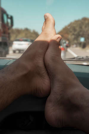 Feet of a man lying on the steering wheel of a car