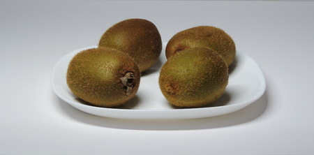 4 kiwi fruit on a white plate.の写真素材