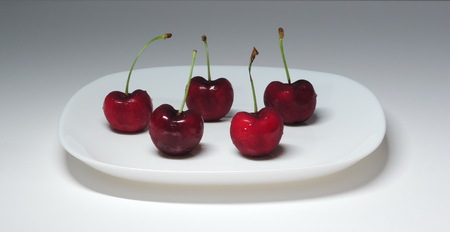 5 cherry on a white plate.の写真素材