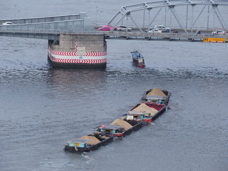 Tug boat that carrying sand was passing under the bridge.の写真素材