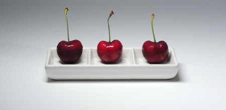 3 cherry on a plate with 3 squares.の写真素材