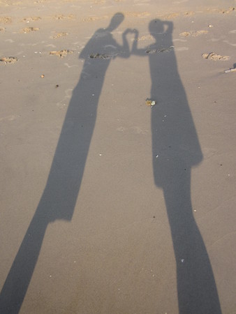 The silhouette of lovers on the sand.の写真素材
