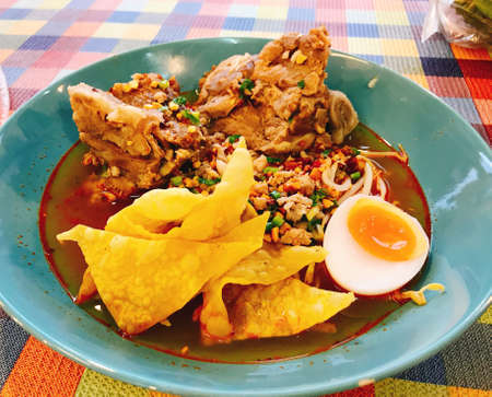 Thai spicy noodle soup with pork bone served with crispy wonton skin.の写真素材