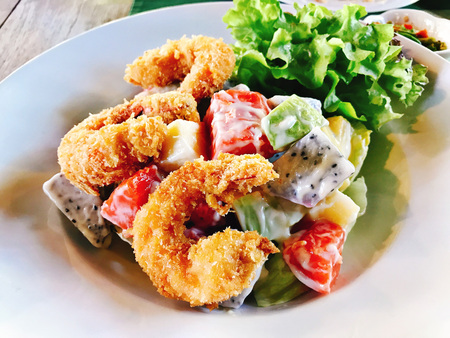 Batter-fried prawn with mixed fruits salad in sweet cream dressing.の写真素材