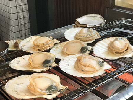 Yummy grilled scallops sold at Kuromon market in Osaka, Japan.