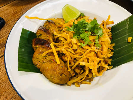 Northern style curry crispy noodle served with Sai ua or Northern Thai sausage or Chiang Mai sausage...