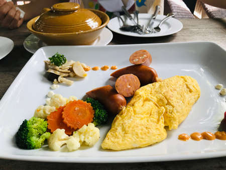 American Breakfast...Omelette served with cheese sausage in Thailand.の写真素材