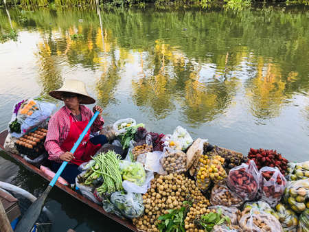 Samut Songkhram, Thailand - August 29, 2020:  A traditional paddle boat sells fruits and vegetables in a canal in Samut Songkhram, Thailand.のeditorial素材