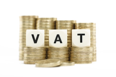 VAT  Value Added Tax  on Stacked Coins with White Backgroundの写真素材