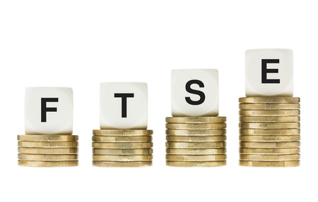 FTSE 100  London Stock Exchange Share Index  on Gold Coin Stacks Isolated on Whiteの写真素材