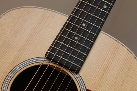 Beautiful close up abstract picture of a classical acoustic guitar with soft light brown beige natural wood grain, ebony fretboard and simple rosette designの写真素材