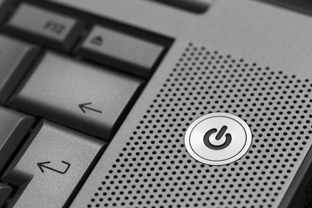 Closeup of silver computer laptop selective focus on standby on button ideal for technology business start power symbolの写真素材