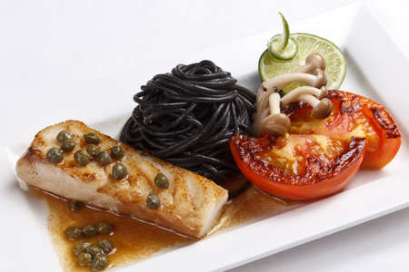 cod fish with black pastaの写真素材