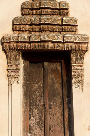 thai art  stucco decorated on a window frame of ancient templeの写真素材