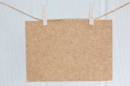 blank cardboard hanging on a ropeの写真素材
