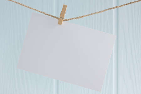 blank photo paper hanging on a ropeの写真素材