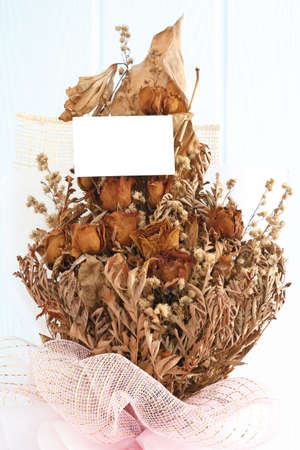 bouquet of dried withered roses with blank white cardの写真素材