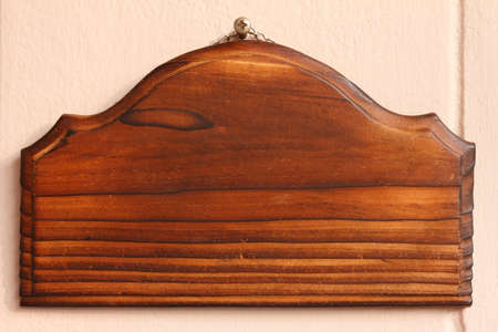blank wooden signboard hanging on concrete wallの写真素材