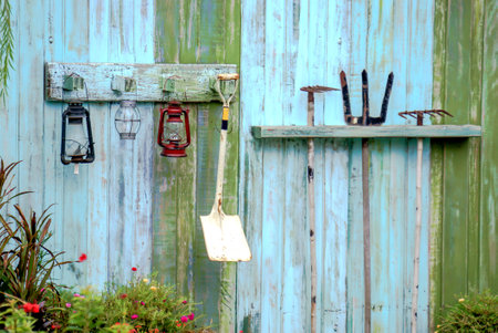 Gardening equipment hanging on blue color wooden wall.の写真素材