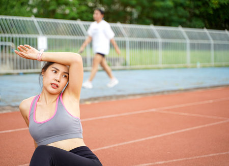 Young female relaxing after fitness training at the football stadium in the morningの写真素材