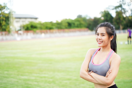 Closeup young female relaxing after fitness training at the football stadium in the morningの写真素材
