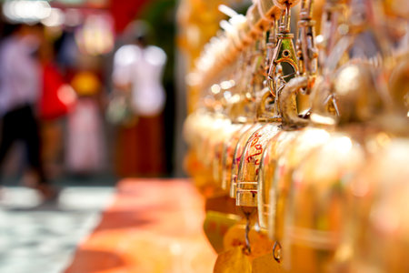 Closeup and perspective view group of small golden bells hang in Thai temple on blurry background.の写真素材