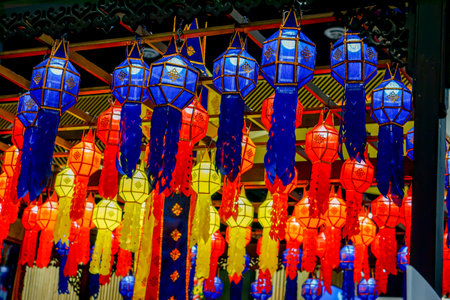 Closeup and look up view of decorated Thai Lanna style lanterns to hang on hotel lobby ceiling background with open lights onの写真素材