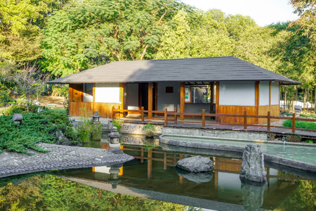 Kyoto, Japan, January 01 2020 : Landscape view of living room of Japanese house area with Japanese garden and pond on natural sun light and green hills background.の写真素材
