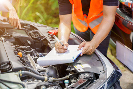 Closeup and crop auto repair checking engine and post a list of repairs according to customer orders...