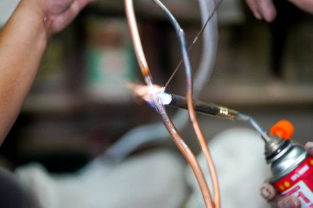 Closeup builder using gas welding to connect the refrigerant pipe.の写真素材