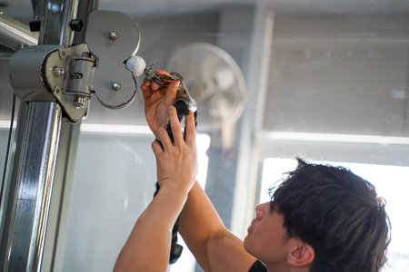 Closeup Asian young officer of the gym and fitness trainer checking fitness equipment at fitness...