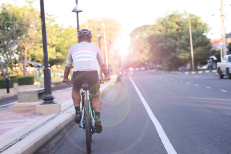 Young man riding bicycle on the road in the morning. Sport and healthy lifestyle concept.の写真素材