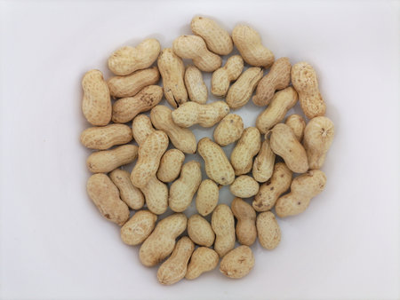 Peanuts in a bowl on a white background, close-up