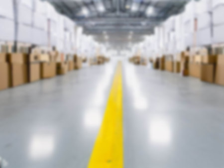 Blurred  A warehouse where the goods are packed in a large number of brown cardboard boxes.の素材