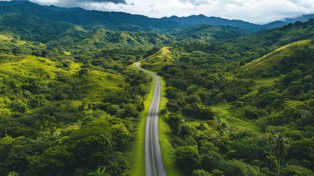 A stunning aerial view of a winding road through lush green mountains, showcasing vibrant nature and a peaceful atmosphere ideal for travel enthusiasts.の素材