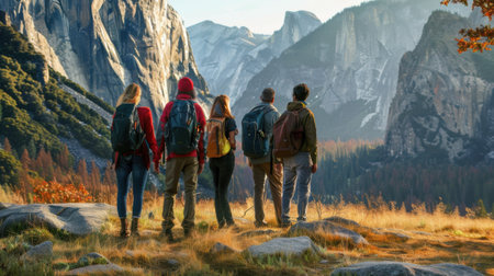 A group of friends stands on a rocky path, admiring a stunning mountain landscape at sunset. The vibrant colors and scenic view create a sense of adventure and camaraderie.の素材
