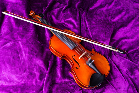 Subject photography. Musical instruments. Violin with bow on a violet background. Background - artificial fur.の写真素材