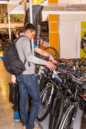 Winter 2015. Russia. Moscow. The exhibition Bikepark-2015. General view. People are walking at the exhibition. They are watching the stands with bicycles, equipment and clothes.のeditorial素材