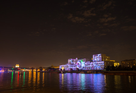 Russia. Moscow - September 26, 2015. The opening of the Festival Circle Of Light. Gorkiy Park. The complex of buildings of the Ministry of Defense and the Andreevskiy Bridge during the Show.のeditorial素材