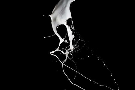 White paint splash isolated on black background.の写真素材