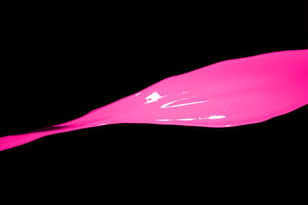 Pink paint splash isolated on black background.の写真素材
