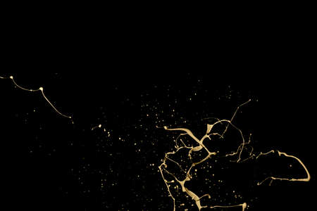 Golden paint splash isolated on black background.