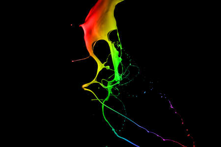 Colored paint splashes isolated on black backgroundの写真素材