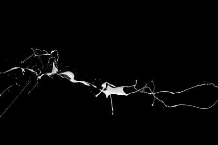 White paint splash isolated on black background.の写真素材