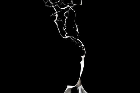 White paint splash isolated on black background.の写真素材